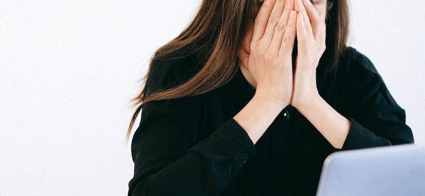 stressed woman covering her face with her hands