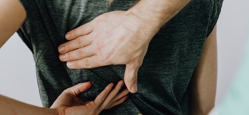 crop orthopedist examining back of anonymous patient in clinic