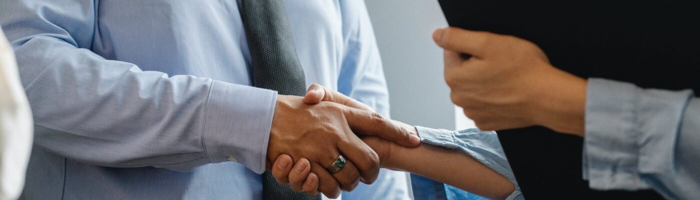 man and woman shaking hands in office