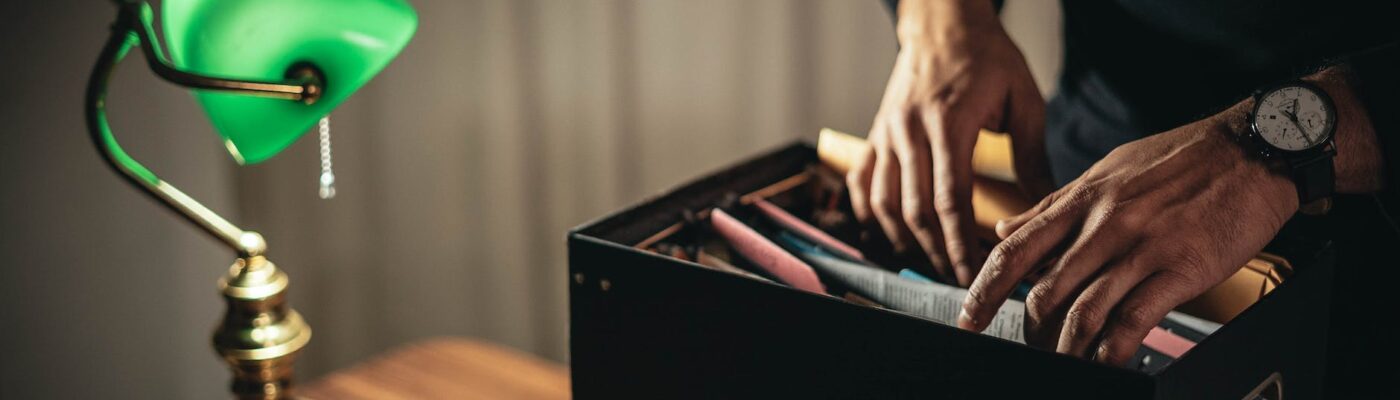 crop unrecognizable man looking through folder in home office